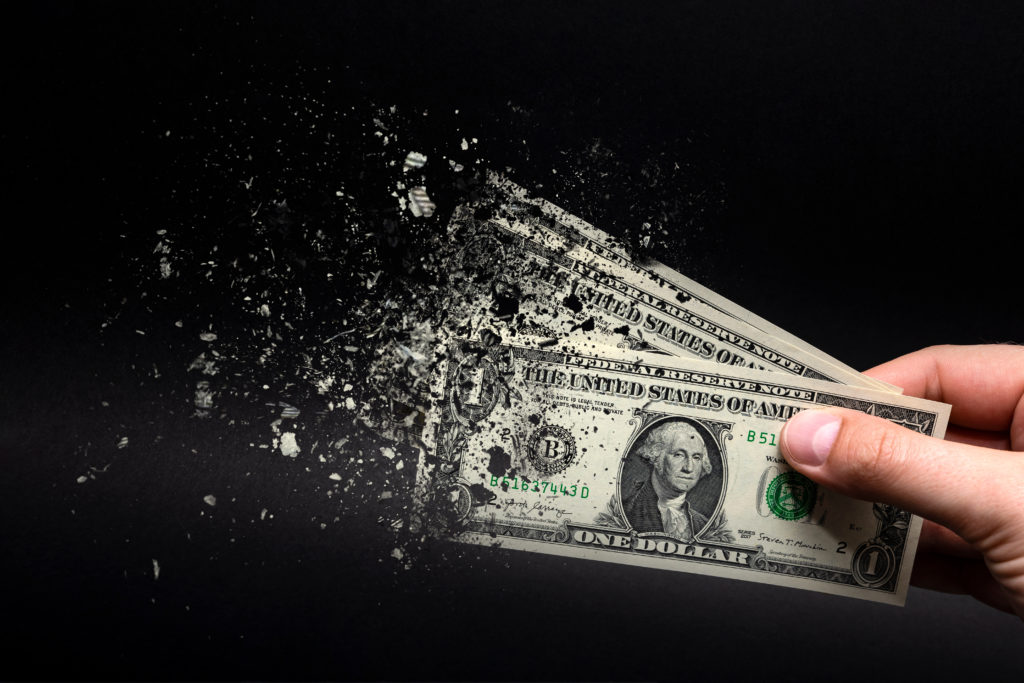 U.S. dollars disintegrating, representing effects of Inflation